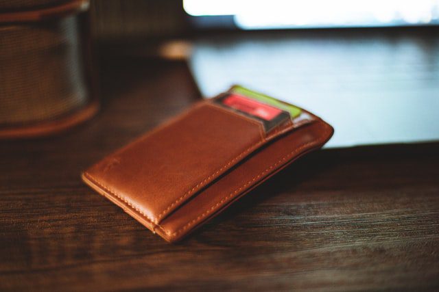 A wallet leaning against a laptop keyboard ready for online shopping