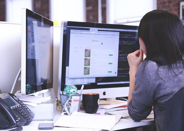 woman at computer with illustrations and code