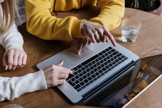 two people viewing a laptop screen