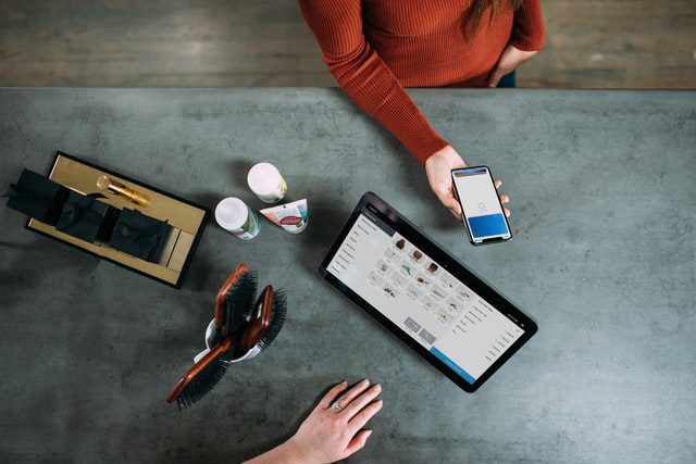 top view of person paying in store using a mobile phone