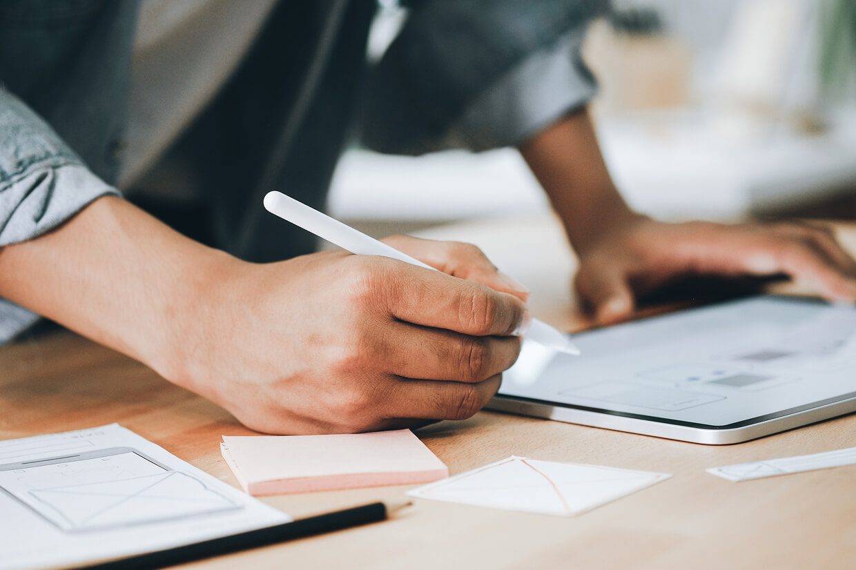 Someone holding a pen with hands on a desk