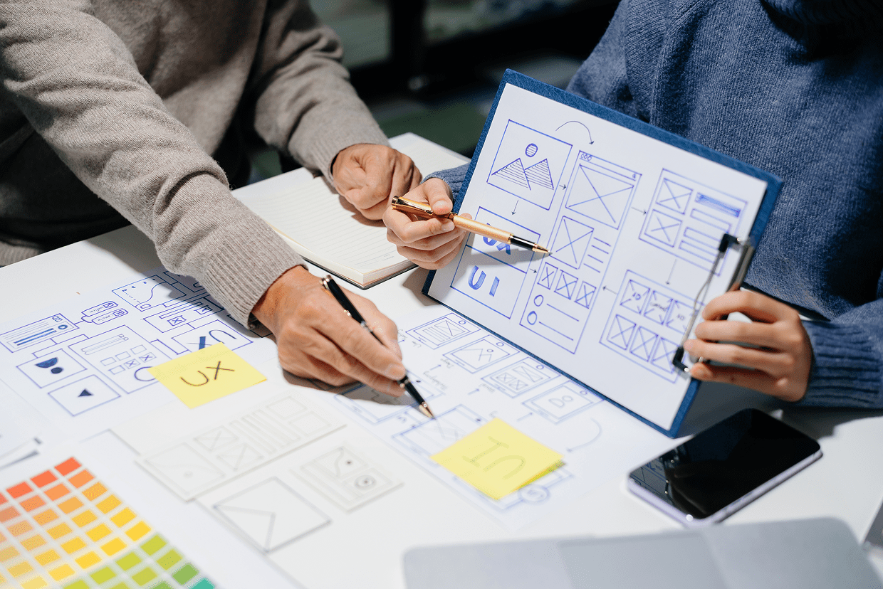 Several mockups on a desk with hands pointing to them