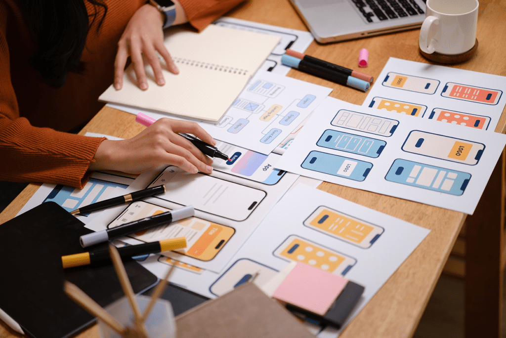 Woman with pink highlighter, open notebook reviewing multiple app and logo images