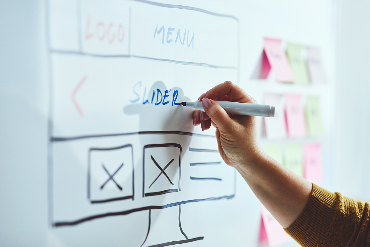 Individual writing in blue ink on a white board