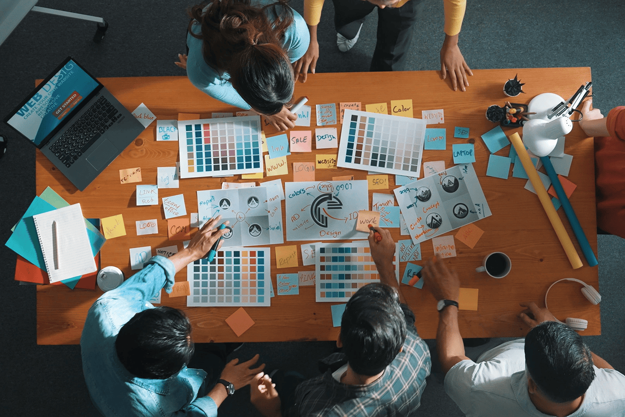 People gathered around a table with multiple colored sheets and sticky notes